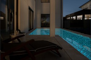 A modern outdoor pool area with a bench and a view of a building in the background. - Spacious 5-Bedroom Resort-Style Sydney Family Home with Private Swimming Pool (Bexley)