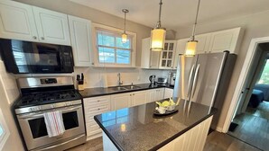 A modern kitchen with stainless steel appliances, white cabinetry, and a granite countertop. - Spacious 2BR Retreat w/Balcony & Gazebo (Brantford)