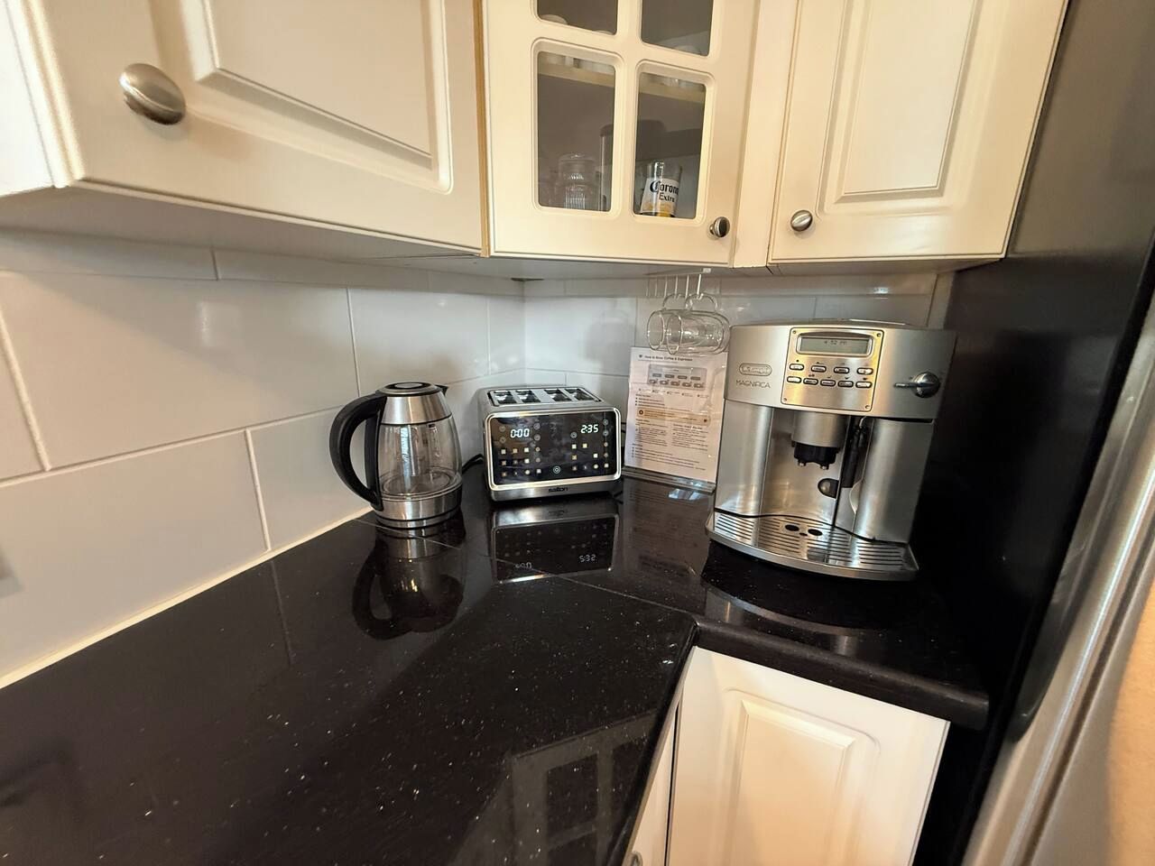 Een keuken met een koffiezetapparaat, broodrooster en waterkoker op het aanrecht.