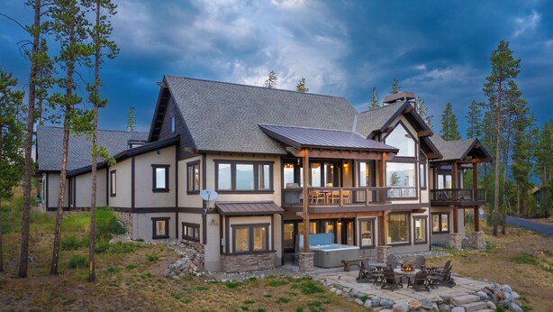 A two-story house with a balcony, a hot tub, and a stone patio. - 1459 GCR 5221 5 bedroom retreat, 10 private acres, outdoor hot tub, game room (Tabernash)