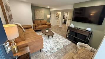 A living room with a sofa, coffee table, and a TV.