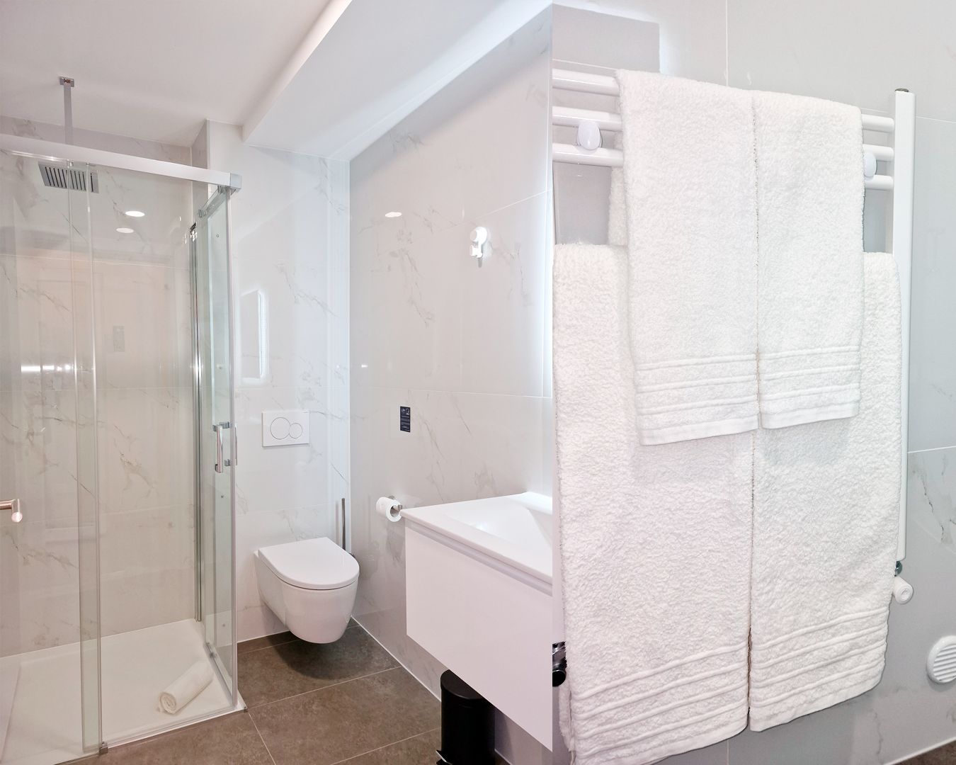 A modern bathroom with a glass-enclosed shower, a toilet, and a towel rack with two white towels.