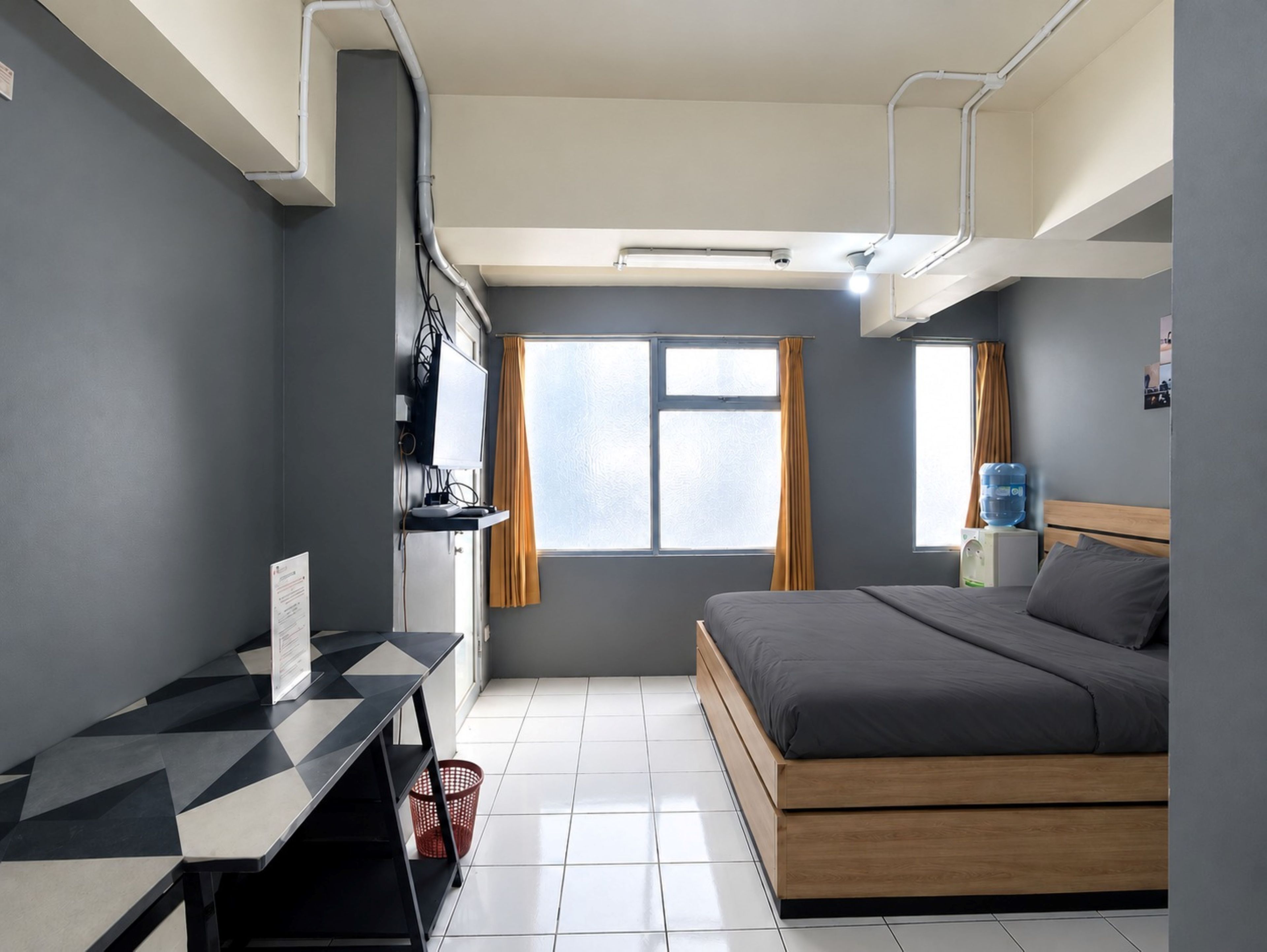 Una habitación de hotel moderna con cama, escritorio y ventana.