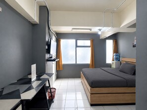 Una habitación de hotel moderna con cama, escritorio y ventana.