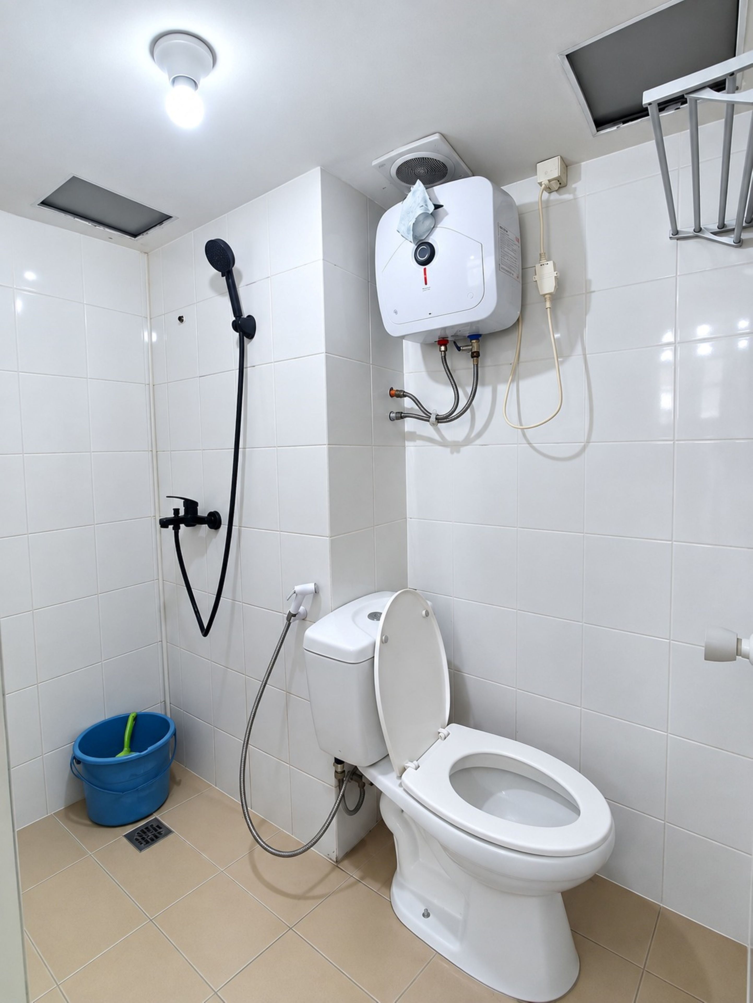 A modern bathroom with a toilet, shower, and a blue bucket.