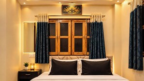 Una habitación de hotel con una cama, una mesita de noche, una lámpara y cortinas.