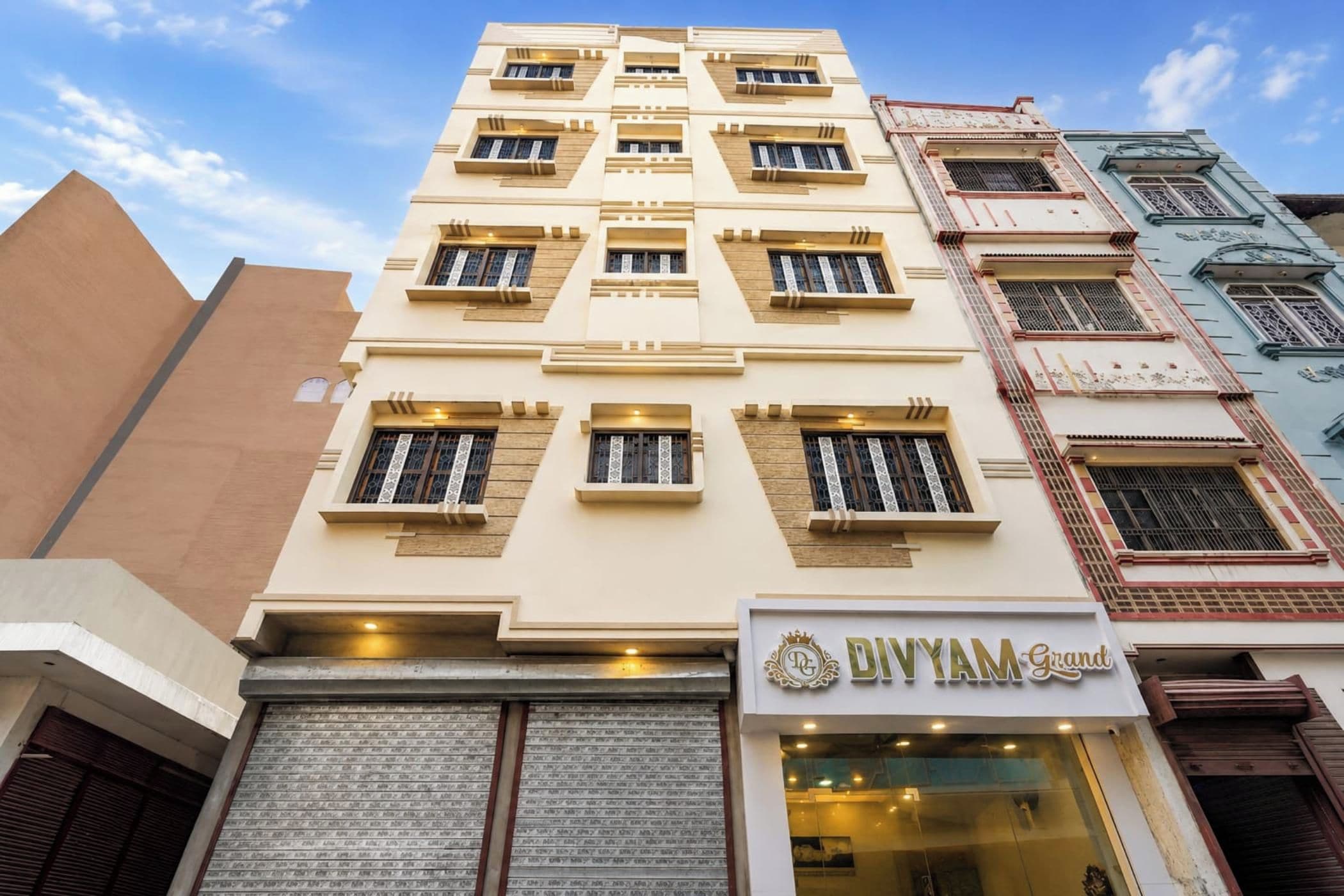 A multi-story building with a ground-level shop named 'DIVYAM Grind'.