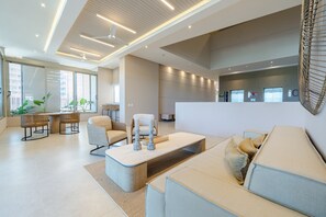 A modern living room with a sofa, a coffee table, and a dining area with chairs. - Bello Horizonte Oceanfront Apartment Suite (Santa Marta)