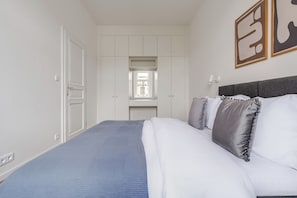 A bedroom with a bed, a window, and a wardrobe. - Vinohrady Residence by Blueground (Prague)