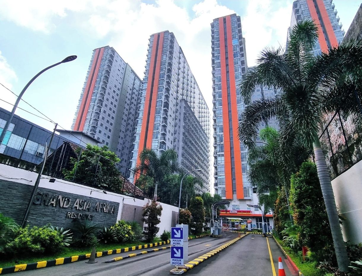A residential area with high-rise buildings, a sign for Grand Asia Marina, and a road with directional signs.