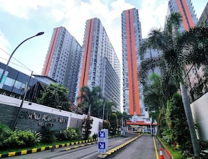 Zona residencial con edificios altos, un cartel que indica Grand Asia Marina y una calle con señales de tráfico.