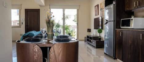 Una cocina moderna con armarios de madera oscura, un refrigerador de acero inoxidable y un microondas.