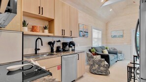 A compact kitchen with modern appliances, a dining area with a sofa, and a view of the outdoors. - **SECRET SAND DOLLAR** Home & Pool + Last Key White Glove Service... (Key West)
