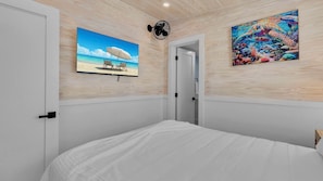 A bedroom with a bed, a door, and two wall-mounted paintings. - **SECRET SAND DOLLAR** Home & Pool + Last Key White Glove Service... (Key West)