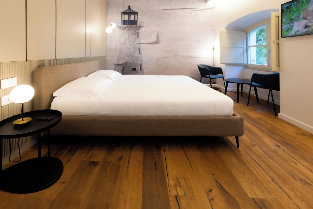 Una habitación de hotel moderna con una cama grande, un escritorio y una silla.
