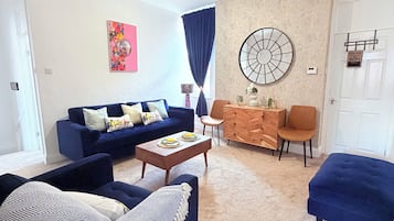 Un salon comprenant un canapé, une table basse et un élément décoratif mural.
