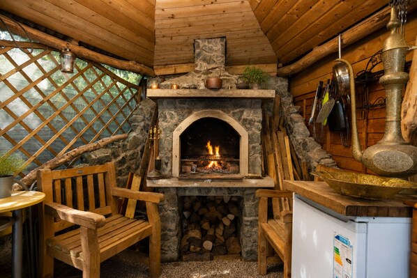 A cozy cabin interior with a stone fireplace, wooden furniture, and a rustic ambiance.