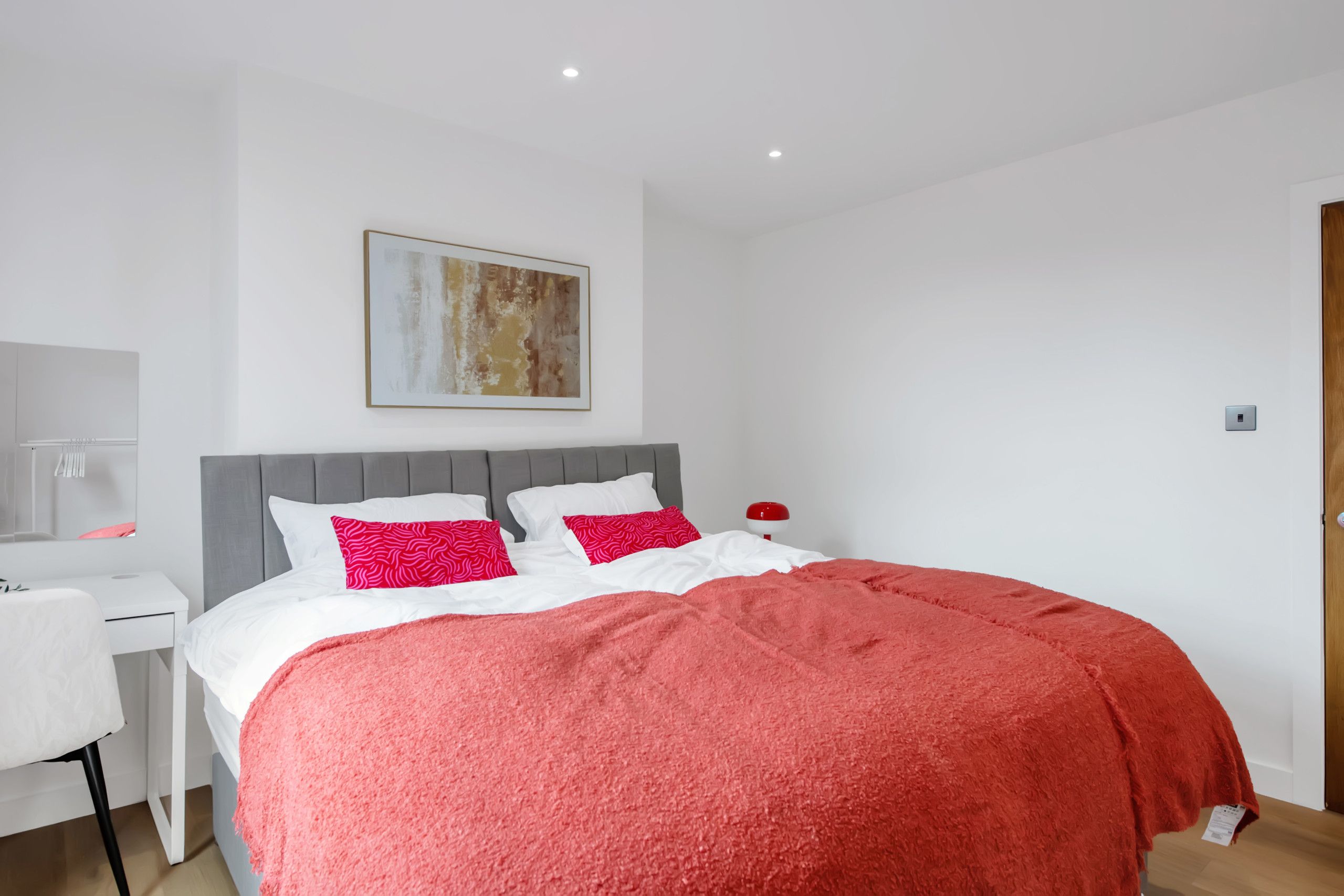 Un dormitorio con una cama, un escritorio y una silla.