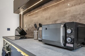 Una cocina moderna con estufa integrada, cafetera y hervidor.