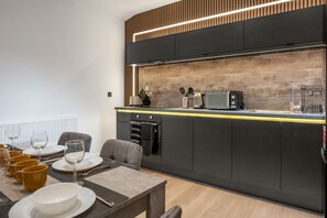 A modern kitchen with a built-in microwave, oven, and a coffee machine. - K Suites - Modern Urban 3 bed House w/ Garden views (Nottingham)