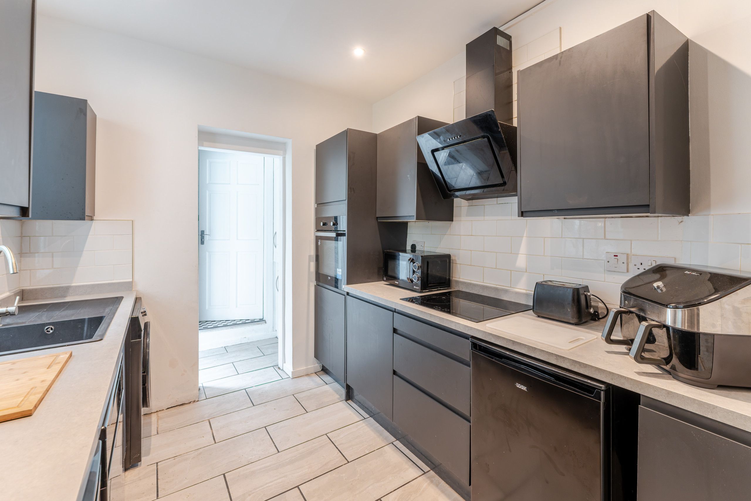 A modern kitchen with a built-in oven, microwave, and toaster.