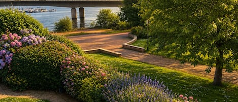 A landscaped garden with a pathway leading to a bridge over water.