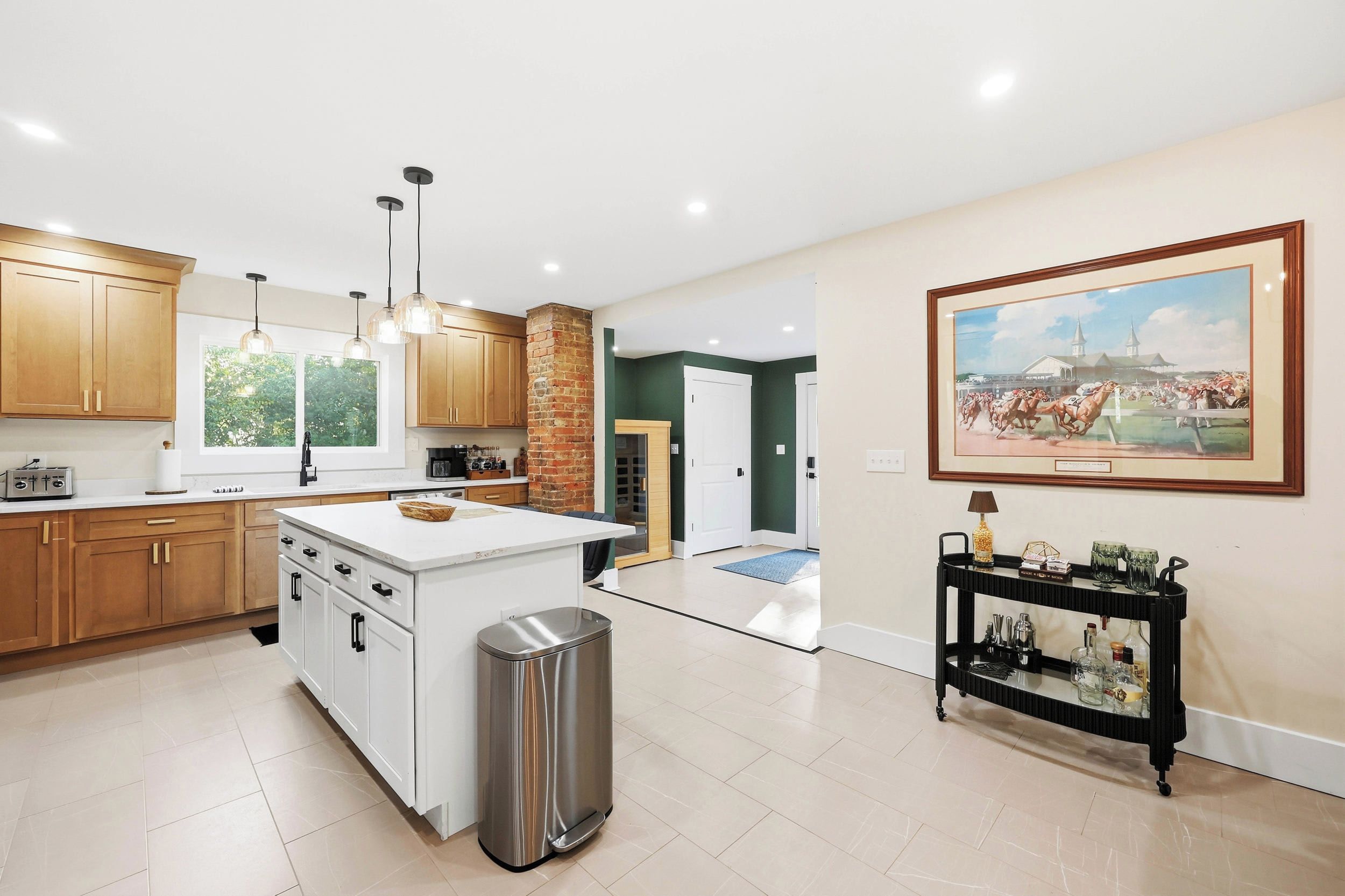 A modern kitchen with wooden cabinets, a central island, and pendant lighting.