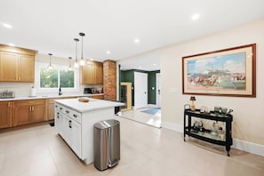 Una cocina moderna con armarios de madera, una isla central e iluminación colgante.