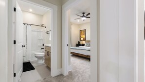 Een badkamer met douche, toilet en wastafel.