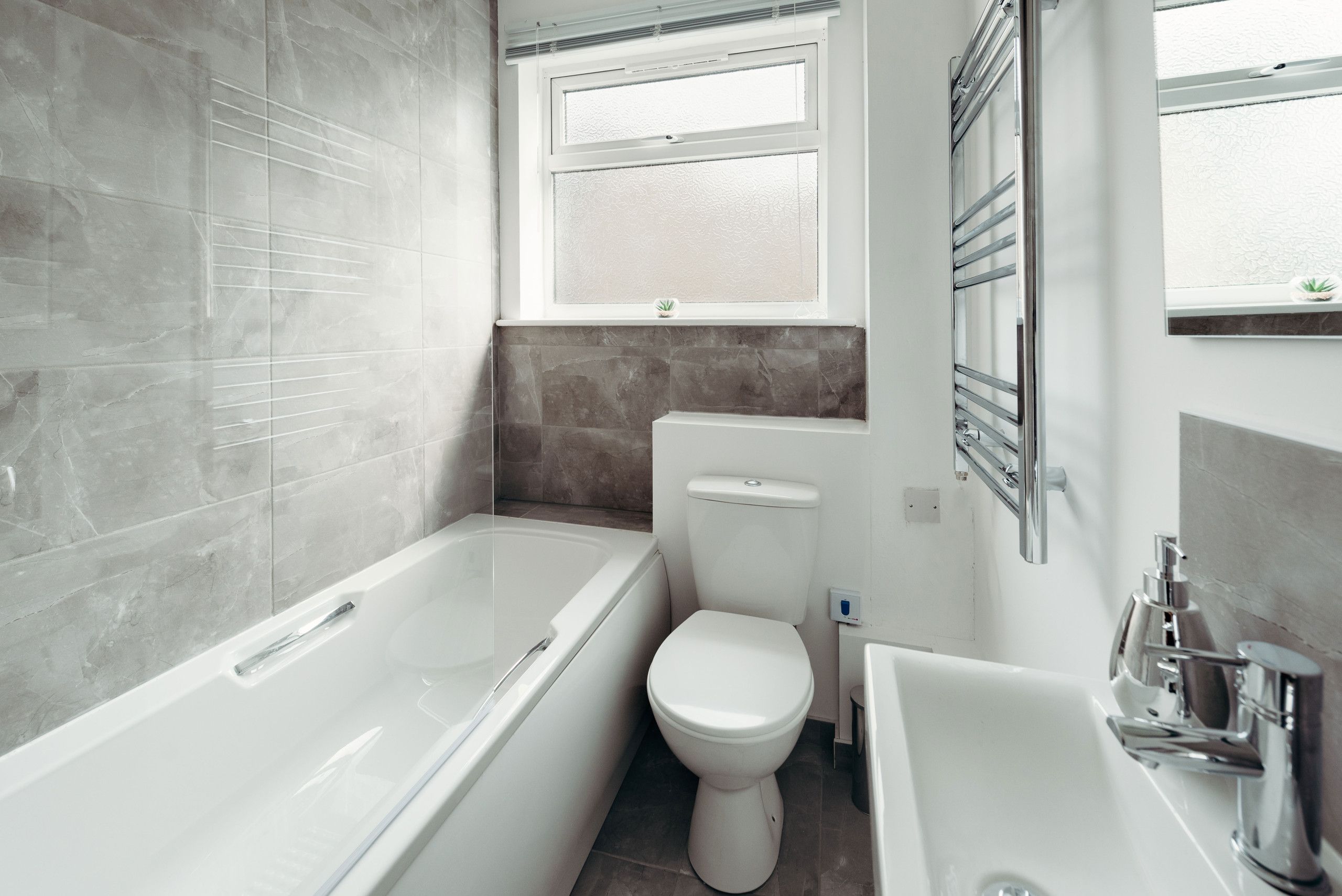 Un bagno moderno con vasca, water e lavabo.