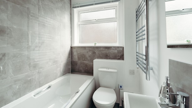 A modern bathroom with a bathtub, toilet, and sink. - K Suites - Quaint 2 Bedroom with Parking (Hinckley)