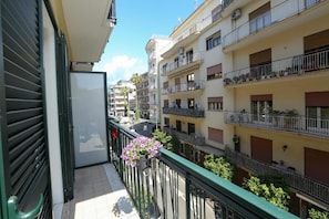 A residential building with multiple balconies, a green awning, and a clear sky. - Ricomincio da Tre (Sorrento)