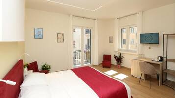 Een hotelkamer met een bed, een bureau, een stoel en een televisie.