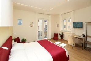 Ein Hotelzimmer mit Bett, Schreibtisch, Stuhl und Fernseher.