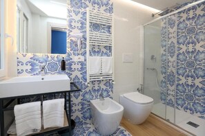 Ein Badezimmer mit Waschbecken, Bidet, Toilette und Dusche.
