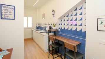 Een moderne keuken met een bar, een bord met huisregels en een blauw-wit betegelde spatwand.