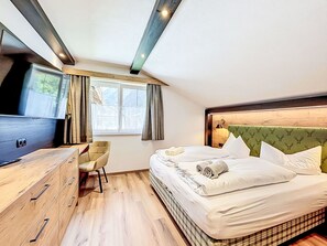 A hotel room with a bed, a desk, a chair, a television, and a window with curtains. - Stunning private villa for 10 guests with WIFI, TV and terrace (Vergötschen)