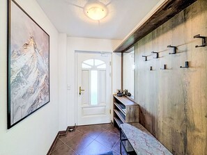 A hallway with a door, a framed artwork, a wooden wall with hooks, and a bench. - Stunning private villa for 10 guests with WIFI, TV and terrace (Vergötschen)
