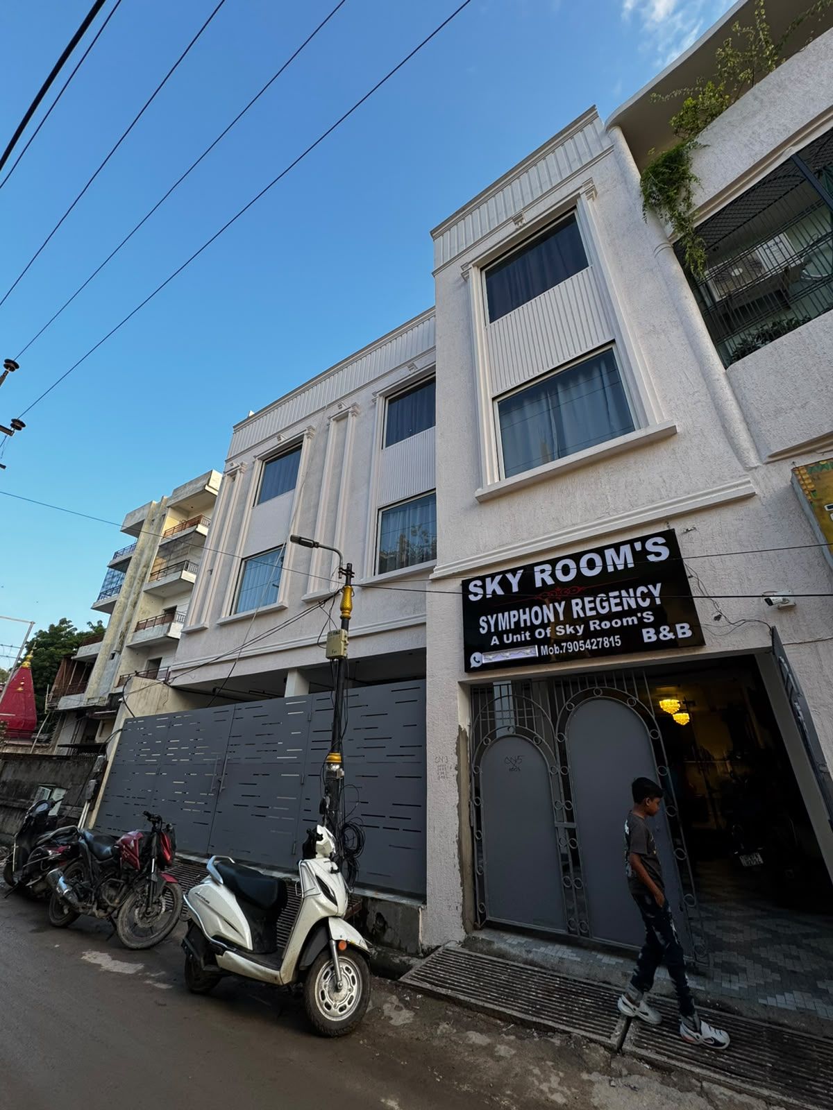 Un edificio con un cartel que indica 'Sky Room's Symphony Regency', señalando una unidad de Sky Room's.
