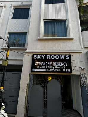 A building with a sign for 'Sky Room's Symphony Regency' indicating it is a unit of Sky Room's. - Hotel Skyrooms Inn (Varanasi)