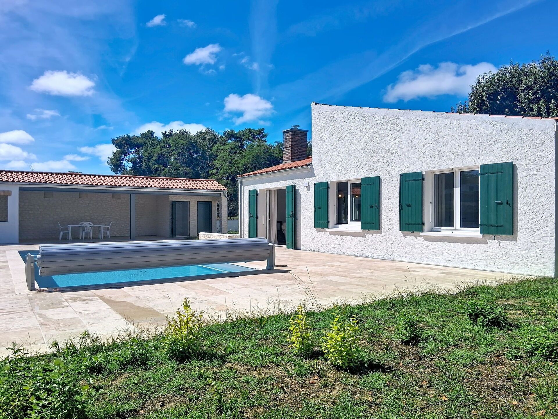 Eine moderne Villa mit Schwimmbad, Terrassensitzgelegenheit und einem gepflegten Garten.