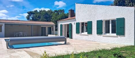 Une villa moderne dotée d’une piscine, d’un espace extérieur aménagé et d’un jardin bien entretenu.