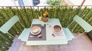 A table set outdoors with a view of a building and greenery in the background. - Urbana Otto - Designer home in the heart of Monti (Roma)