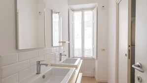 A bathroom with two sinks, a mirror, and a window. - Urbana Otto - Designer home in the heart of Monti (Roma)
