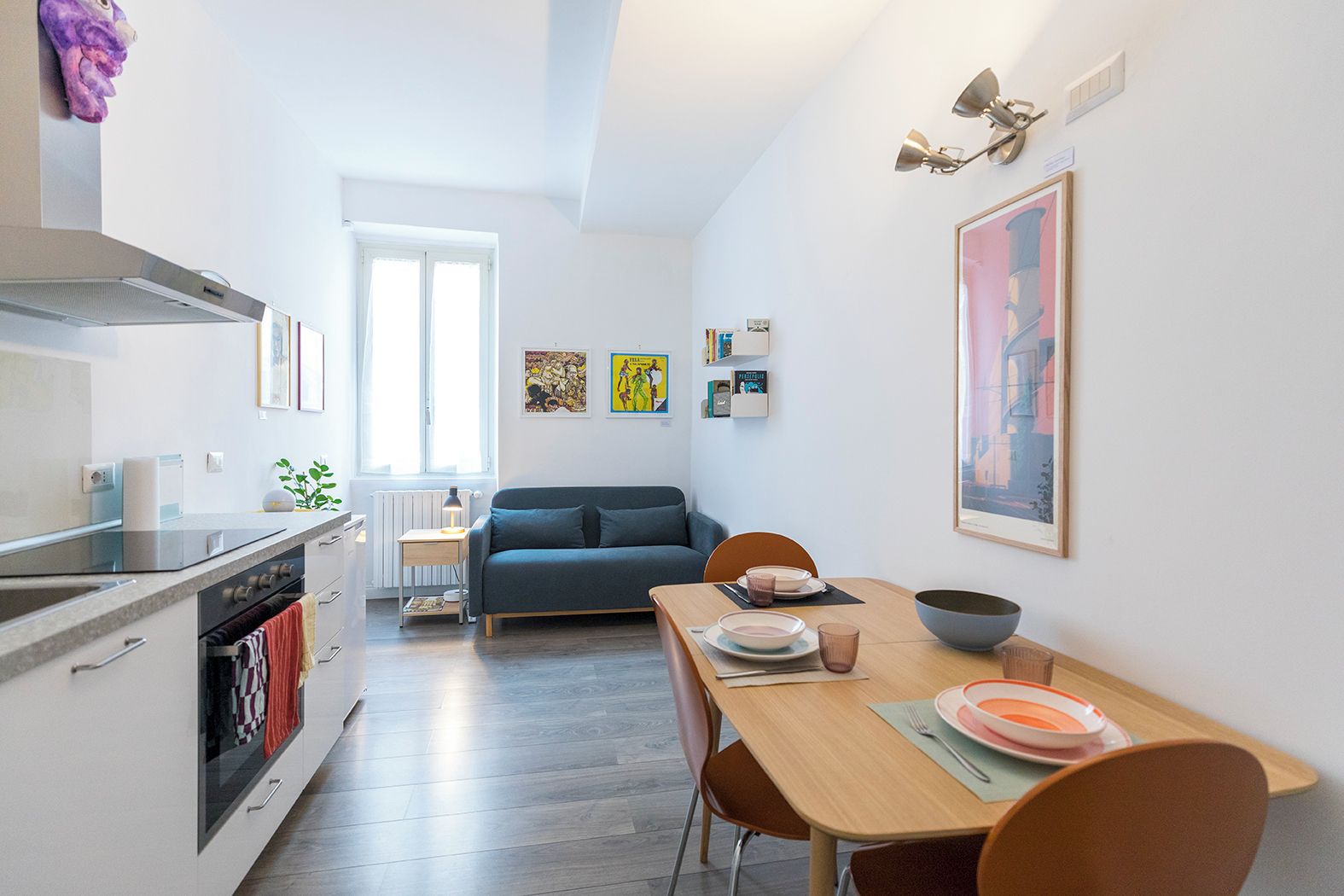 A modern kitchen with a built-in oven and a dining area with a table set for two.