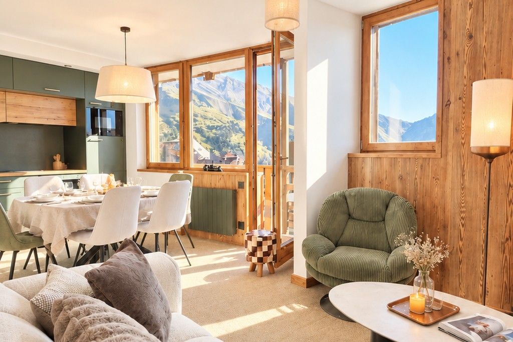 A cozy living area with a sofa, a dining table set for two, and a view of mountains through large windows.