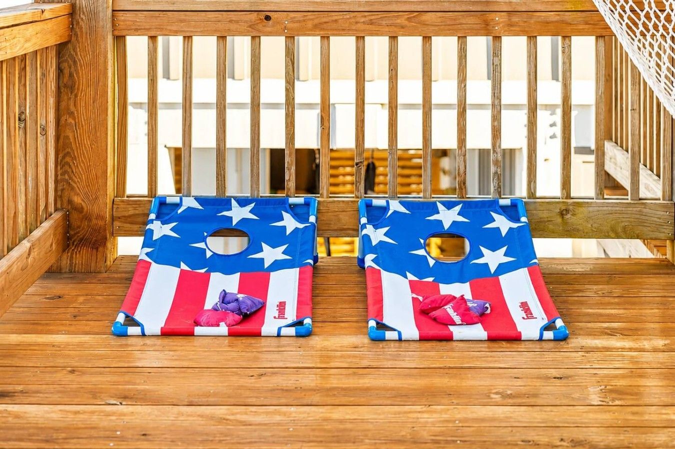 Two American flag-themed bean bags on a wooden deck.