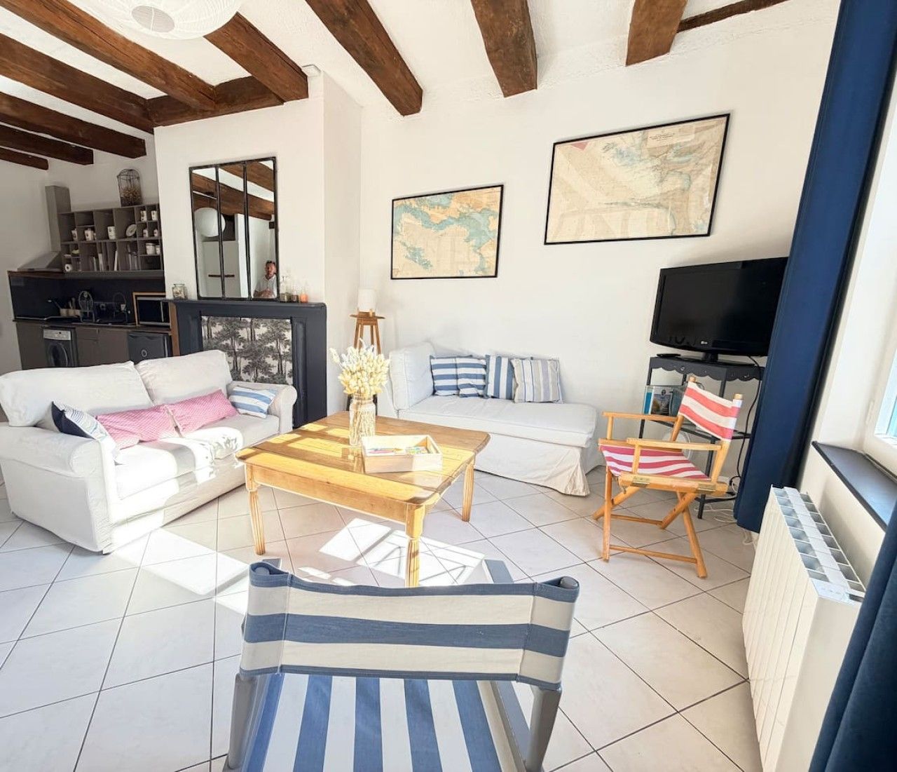 Un salon avec un canapé, une table basse, un téléviseur et un fauteuil.