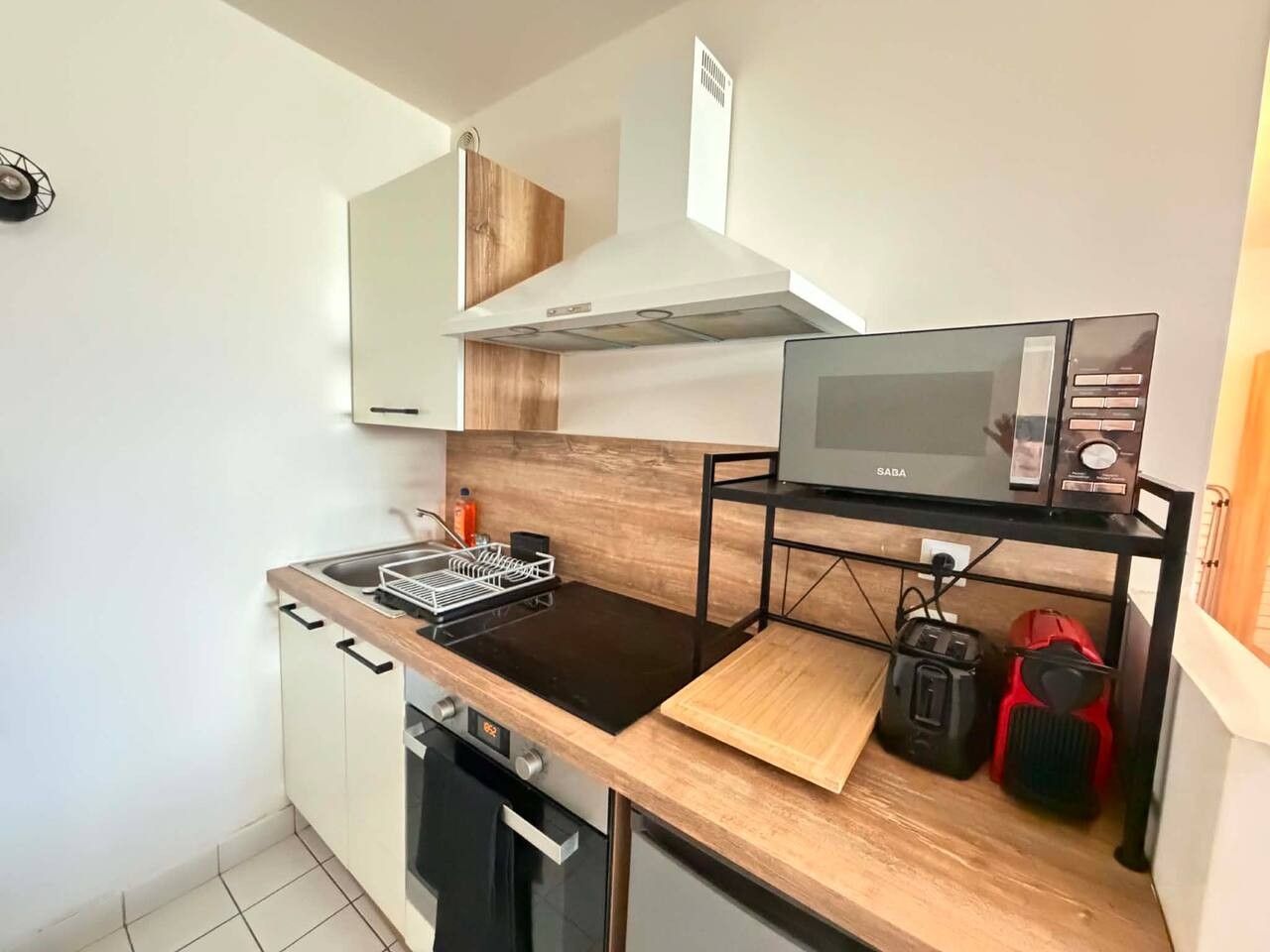 A compact kitchen with a microwave, a toaster, and a compact dishwasher.