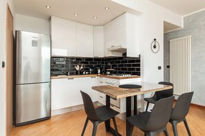A modern kitchen with a stainless steel refrigerator, black tiled backsplash, and a wooden countertop. - New Two-Room Apartment - 100 meters from the Aquarium (Genova)